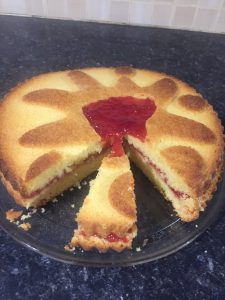 Jammie Dodger cake complete after using silicone cake mould, with slice ready for eating